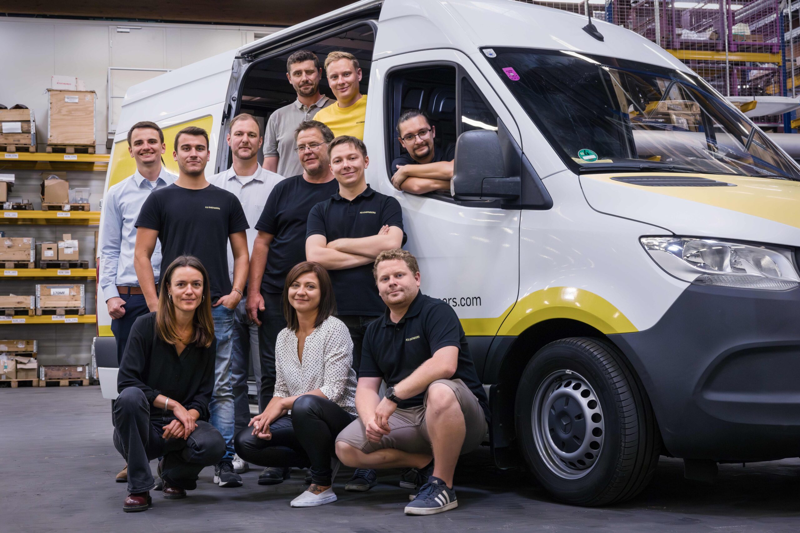 Gruppenfoto eines Teams vor einem Lieferwagen