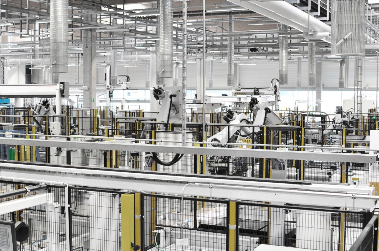Das Bild zeigt eine moderne industrielle Produktionshalle mit Fertigungsanlagen.